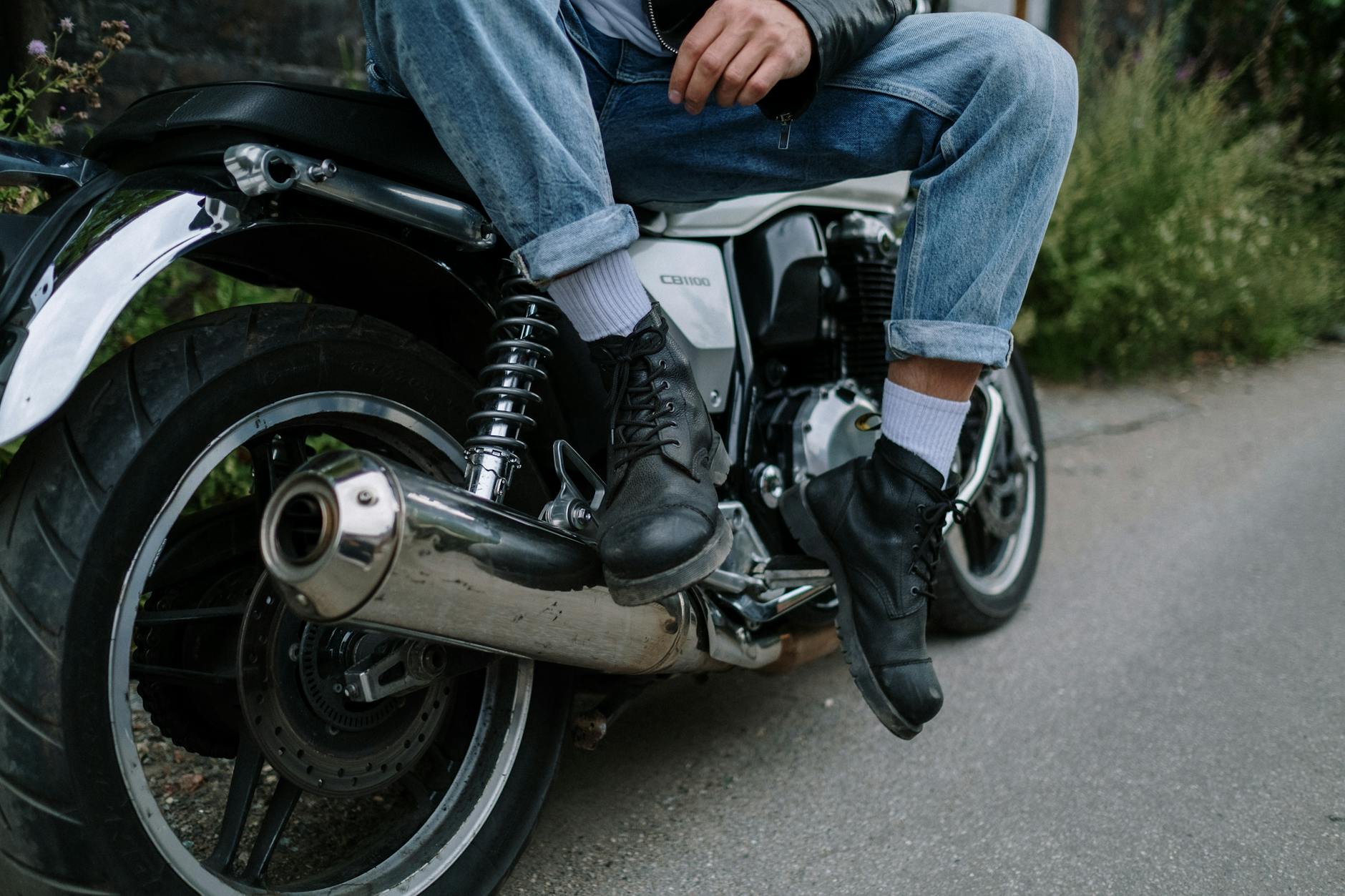 A person applying conditioner to leather motorcycle boots