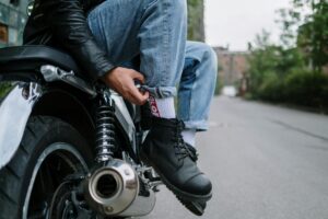 A rider wearing sturdy motorcycle boots while cruising on a scenic road